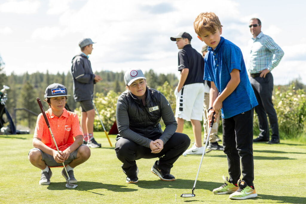young boy training with golf pro at tetherow resort golf course